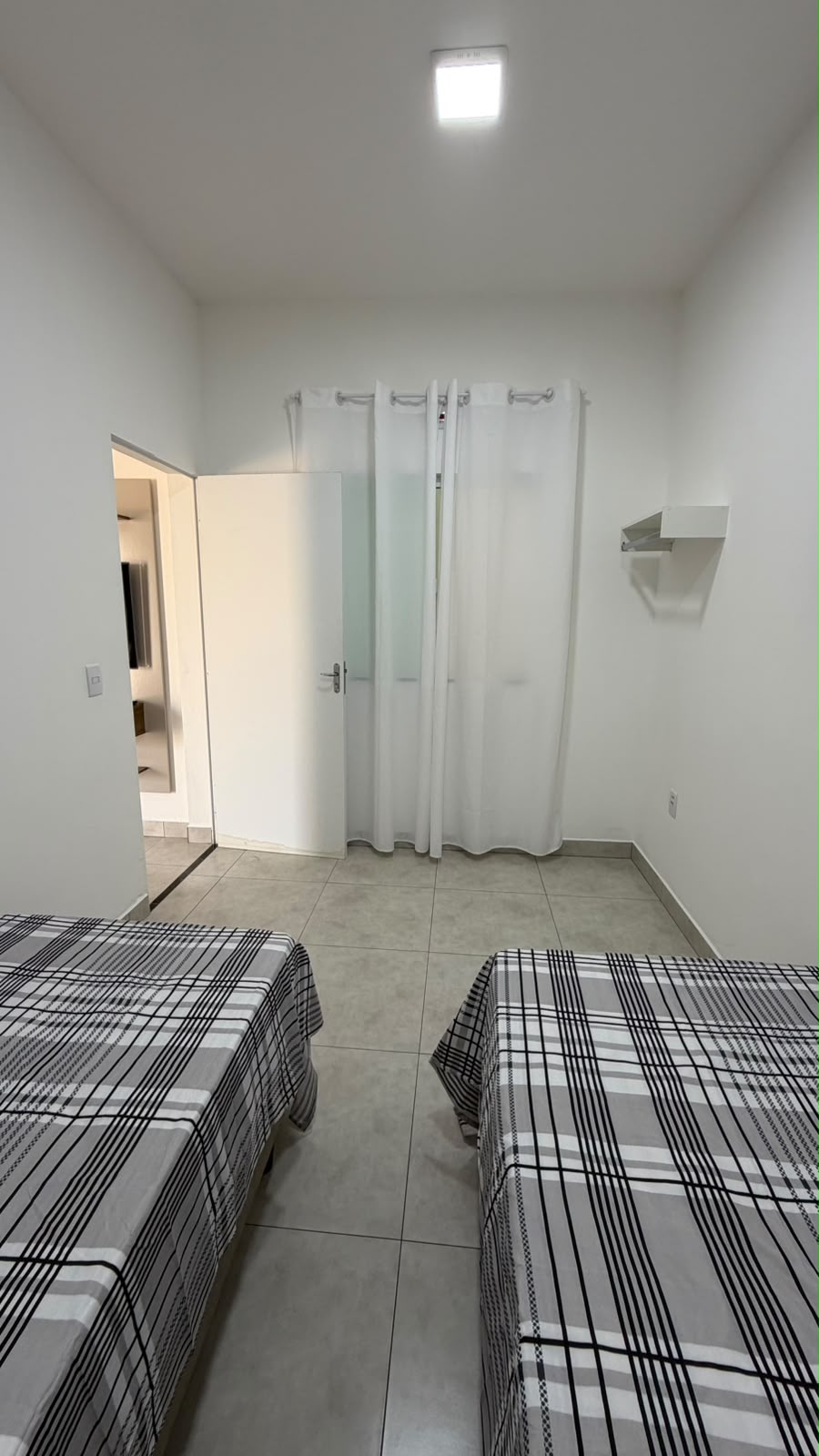 Outro ângulo do quarto com duas camas de solteiro