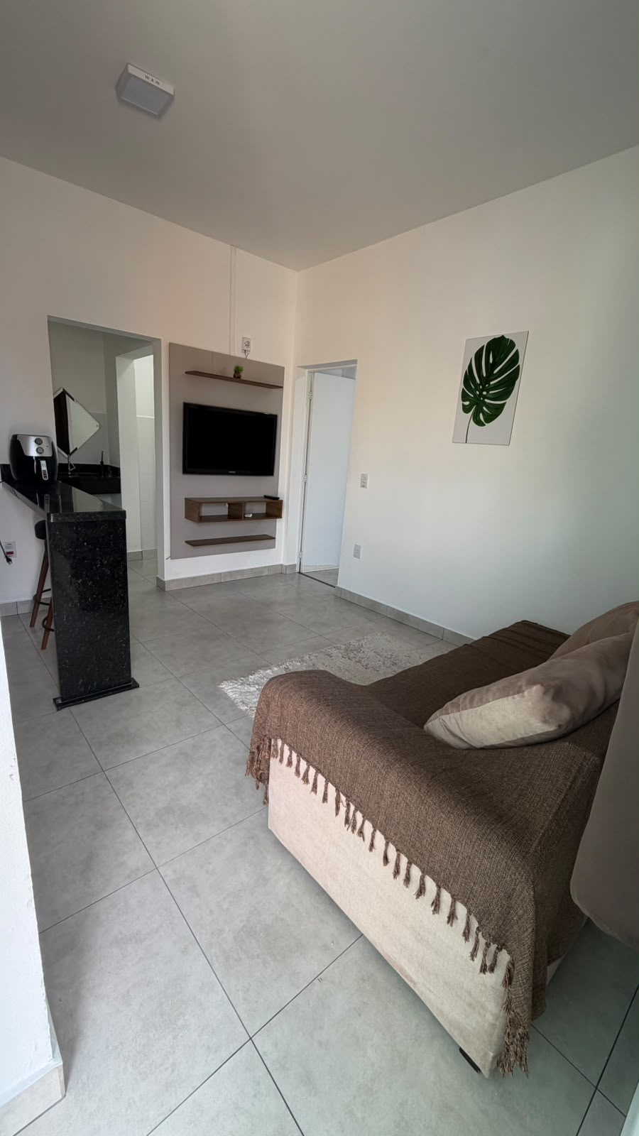 Sala de estar com sofá e TV na Bella Home